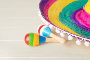 Meksika sombrero ve marakas beyaz ahşap arka planda, yakın plan