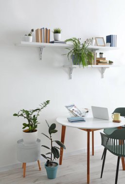 Kitapları ve yemek masası olan raflar odanın içinde.