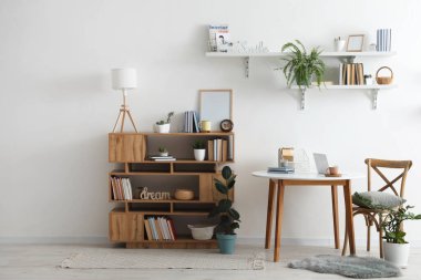 Kitapları ve masası olan raf ünitesi