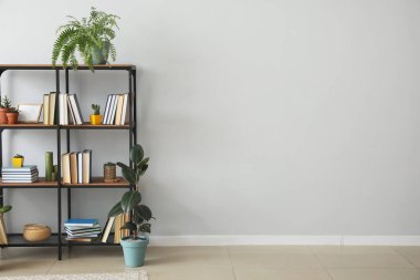Açık duvarın yanında kitapları olan raf ünitesi