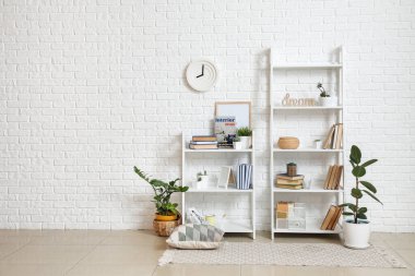Kitaplı raflar ve hafif tuğla duvarın yanındaki dekorlar