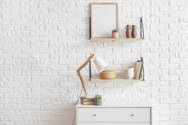 Çekmeceler ve raflar tuğla duvarın yanında dekorlu.