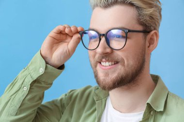 Renkli arka planda gözlük takan genç adam