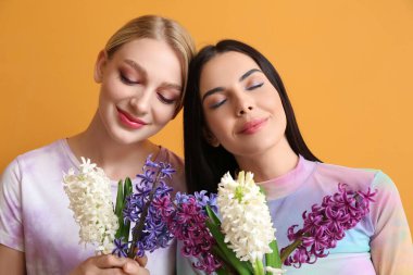 Arka planda sümbül çiçekleri olan güzel genç kadınlar.