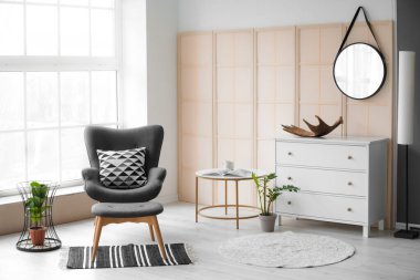 Rahat koltuğu ve masası olan modern bir oda.