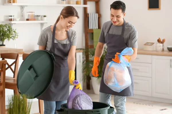 Janitors throwing garbage in bin at home