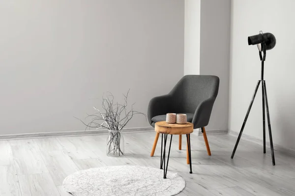 Modern Fotel Asztallal Lámpával Vázával Világos Fal Mellett Szobában — Stock Fotó