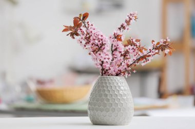 Odada çiçek açan güzel dalları olan bir vazo.