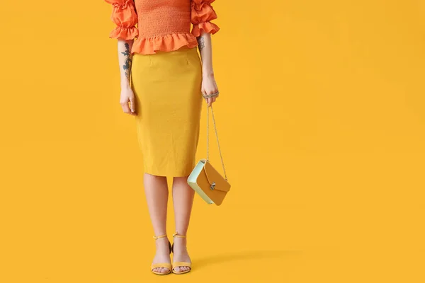 黄色の背景に袋を持つスタイリッシュな若い女性 — ストック写真