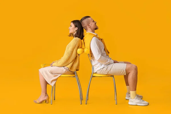 Gelukkig Jong Paar Zitten Stoelen Tegen Gele Achtergrond — Stockfoto