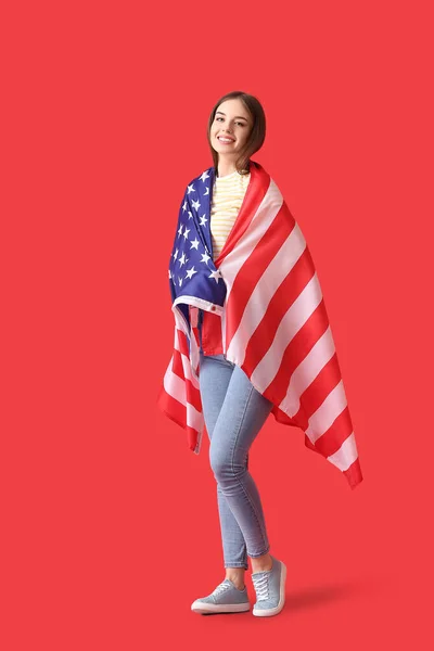 stock image Beautiful young woman with USA flag on color background