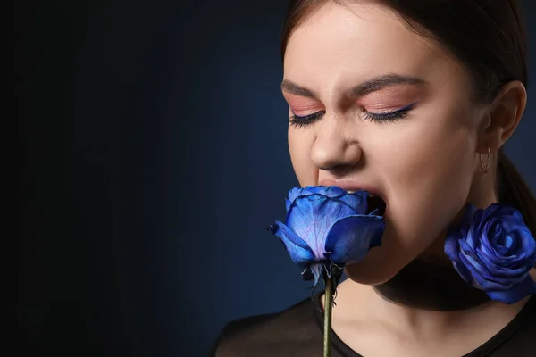 美丽的年轻女子 背景是深蓝色的玫瑰 — 图库照片