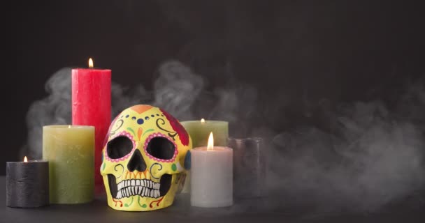用燃烧的蜡烛和浓烟在黑暗的背景上涂上人类骷髅作为纪念墨西哥人的纪念日 — 图库视频影像