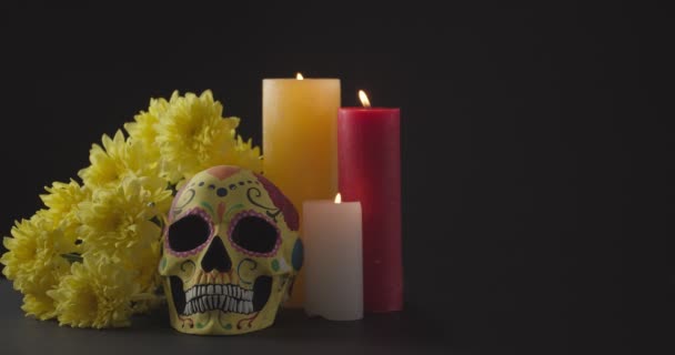 用燃烧的蜡烛和深色背景的花朵装饰人类骷髅以纪念墨西哥人死亡日 — 图库视频影像