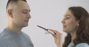 Tatlı çikolatalı genç bir kadın açık arka planda erkek arkadaşıyla alay ediyor.