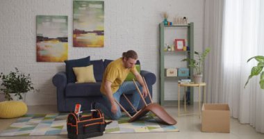 Genç çift evde mobilya montajını bitirdikten sonra kahve içer.