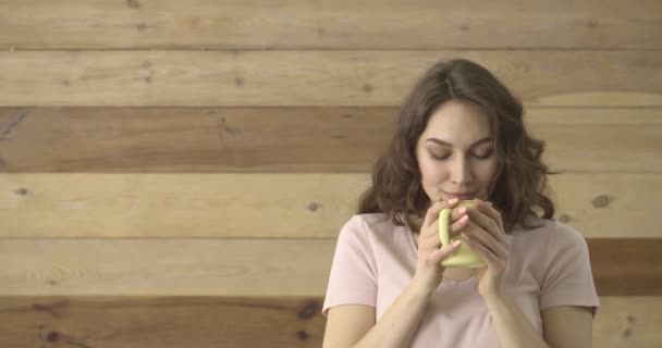 快乐的年轻女子喝着热茶 而男人则在木制背景下送给她甜巧克力 — 图库视频影像