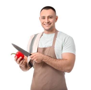 Young man cutting fresh pepper on white background clipart