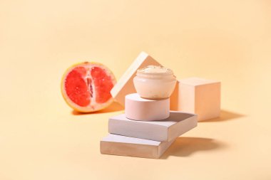 Renkli arkaplanda kozmetik kil ve greyfurt kavanozu