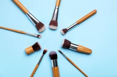 Renk arkaplanındaki makyaj fırçalarından yapılmış çerçeve