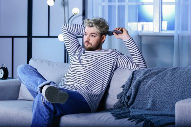 Genç adam gece televizyon izliyor. Bağımlılık kavramı