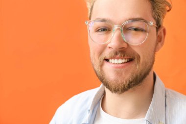 Renkli arka planda gözlük takan genç adam