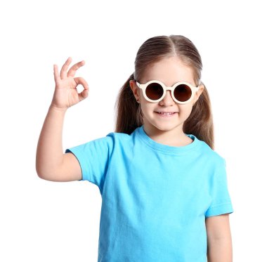 Şık güneş gözlüğü takan ve beyaz arka planda iyi gözüken sevimli küçük kız.