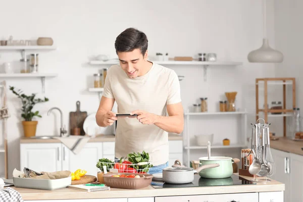 Genç Adam Mutfakta Taze Sebzelerin Fotoğrafını Çekiyor — Stok fotoğraf