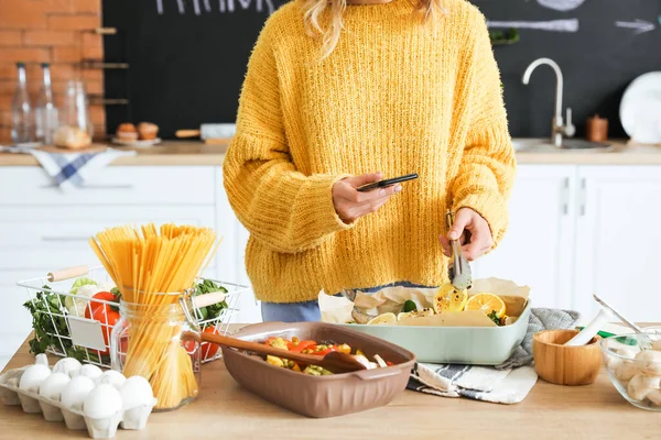 Young Woman Taking Photo Baking Dish Fish Vegetables Kitchen —  Fotos de Stock