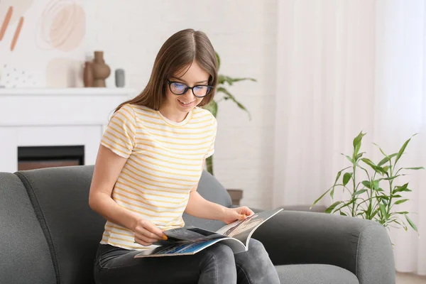 Young Woman Wearing Eyeglasses While Reading Magazine Home — Stock Photo, Image