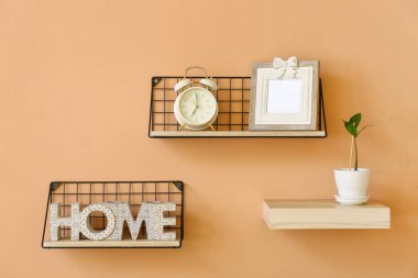 Renk duvarında alarm saati ve dekor asılı raflar