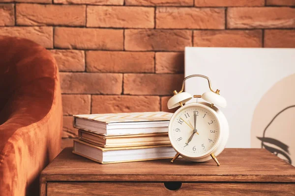 Mesa Com Despertador Livros Perto Parede Tijolo Quarto — Fotografia de Stock