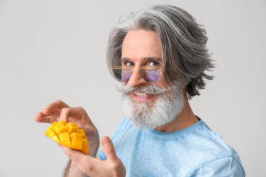 Arka planda kesilmiş mangolu kıdemli adam.