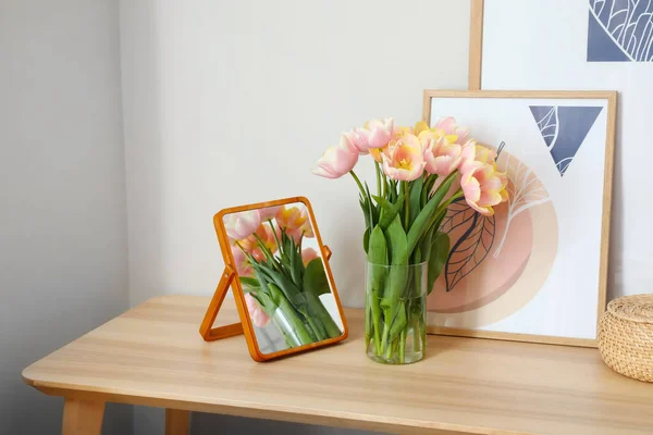 部屋の白い壁の近くのテーブルの上に美しいチューリップの花の花束 — ストック写真