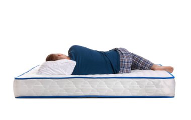 Genç adam beyaz arka planda yumuşak bir yatakta uyuyor.