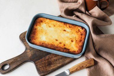 Hafif arka planda lezzetli süzme peynirli güveç.