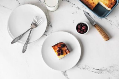 Açık arkaplanda süzme peynirli güveç tabağı.