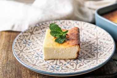 Ahşap arka planda süzme peynirli güveç tabağı.