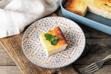 Ahşap arka planda süzme peynirli güveç tabağı.