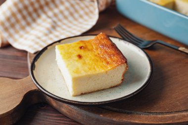 Ahşap arka planda süzme peynirli güveç tabağı.