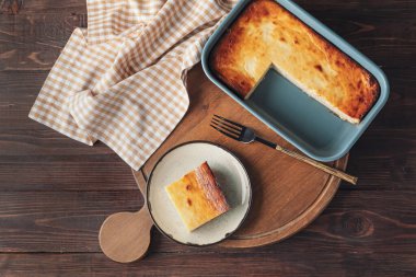 Ahşap arka planda süzme peynirli güveç tabağı.