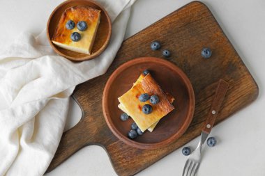 Açık arkaplanda süzme peynir güveci parçaları olan tabaklar