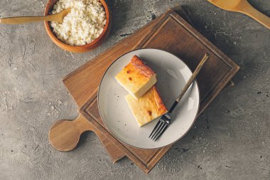 Grunge arka planında süzme peynir güveci parçaları olan tabak.