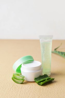 Renk arka planında aloe yaprakları olan kozmetik ürünleri