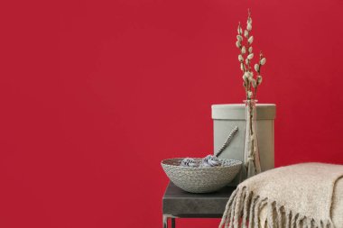 Söğüt dallı vazo ve masa üzerinde renkli arka planda bir kase kek.