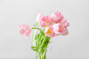 Açık arkaplanda güzel lale çiçekleri olan vazo.