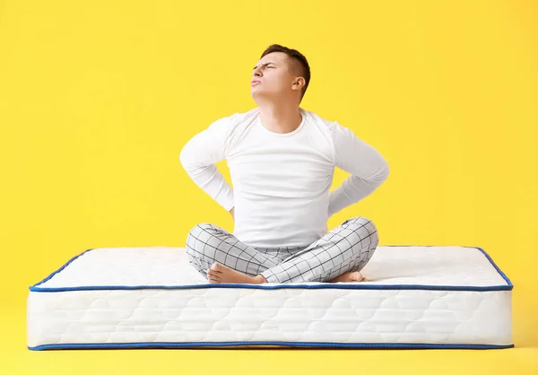 Young Man Suffering Pain Mattress Color Background — Stock Photo, Image