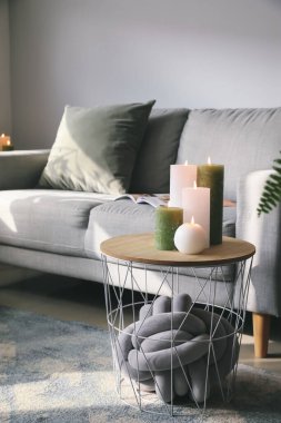 Oturma odasındaki masada mum yakmak.