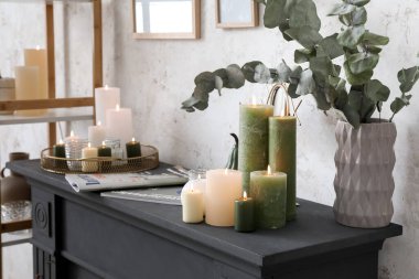 Süslü dekorlar ve şömine rafında yanan mumlar.