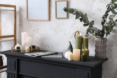 Süslü dekorlar ve şömine rafında yanan mumlar.